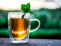 Kräutertee im Glas mit Minzblatt