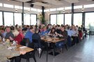 Die Gäste sitzen im Restaurant "Grill- und Kochschule Reiser" zur Weinverkostung