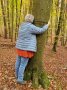 Eine Teilnehmerin umarmt eine Buche