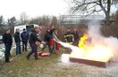 Mann löscht Feuer mit Feuerlöscher.